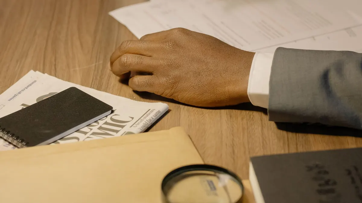 A magnifying glass resting on documents and a folder on a desk