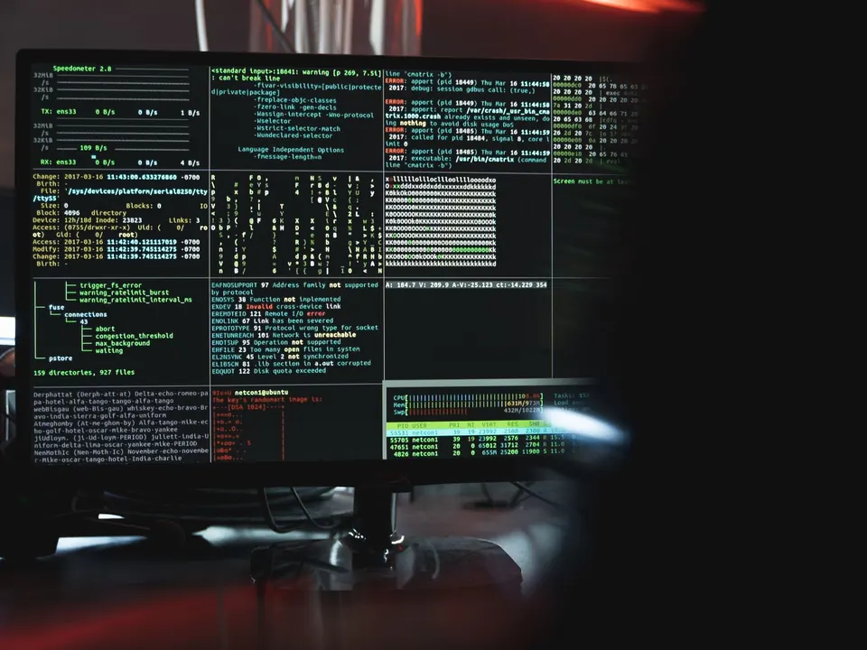 A monitor showing lines of terminal output in a dark room